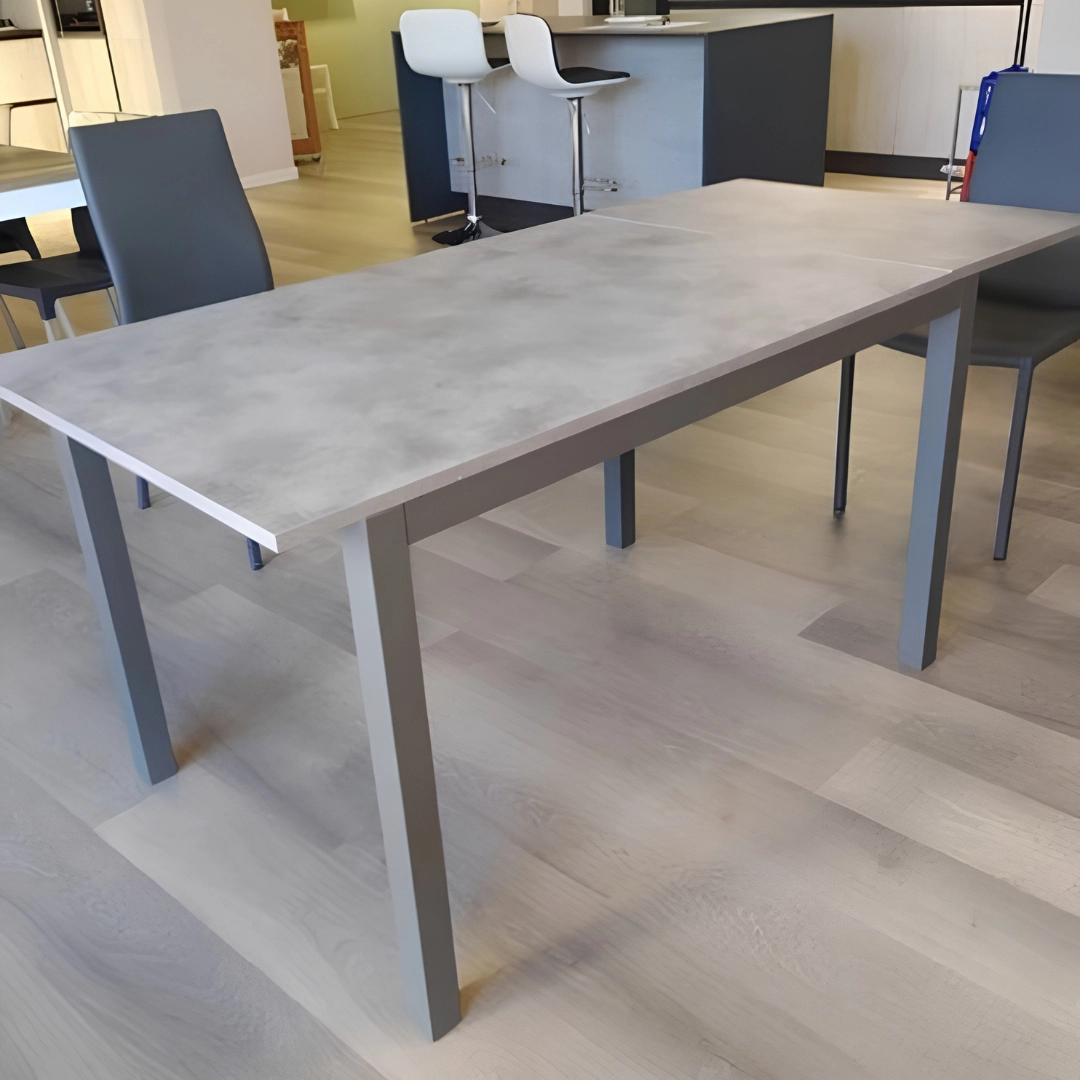 Tavolo allungabile moderno con piano esteso in un ambiente arredato con sgabelli