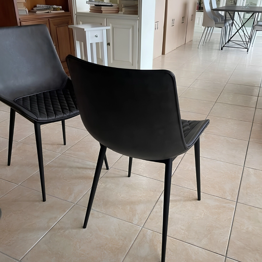 Vista posteriore e di profilo di due sedie da pranzo moderne nere in ecopelle e metallo verniciato