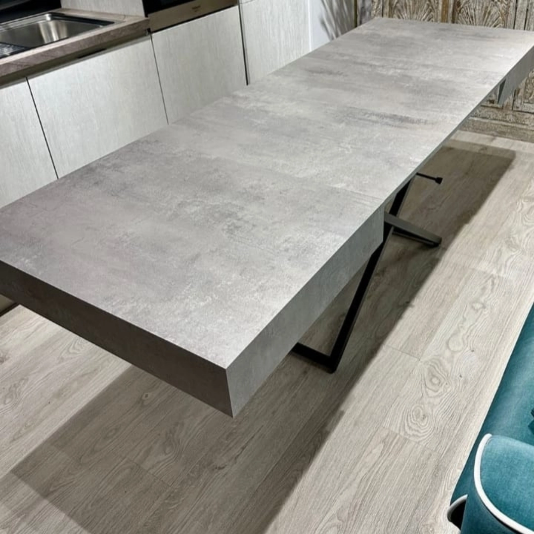 Tavolo da pranzo moderno completamente allungato con piano nobilitato grigio effetto cemento