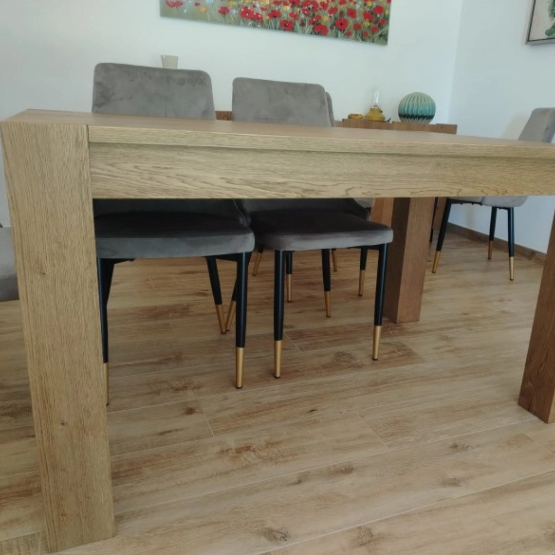 Primo piano della gamba massiccia del tavolo in rovere Marca Design Shop, che mostra la solidità della struttura e la venatura del legno.
