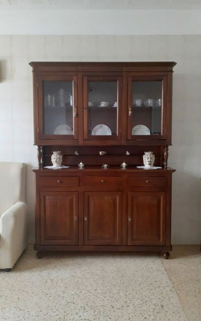 Dettaglio frontale vetrina 3 porte noce scuro con oggetti decorativi