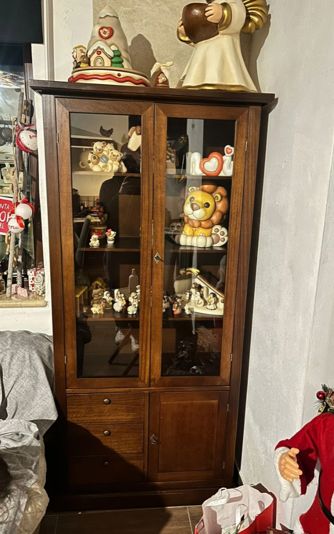 Vetrina classica in legno finitura noce utilizzata come mobile espositore per soprammobili in ceramica